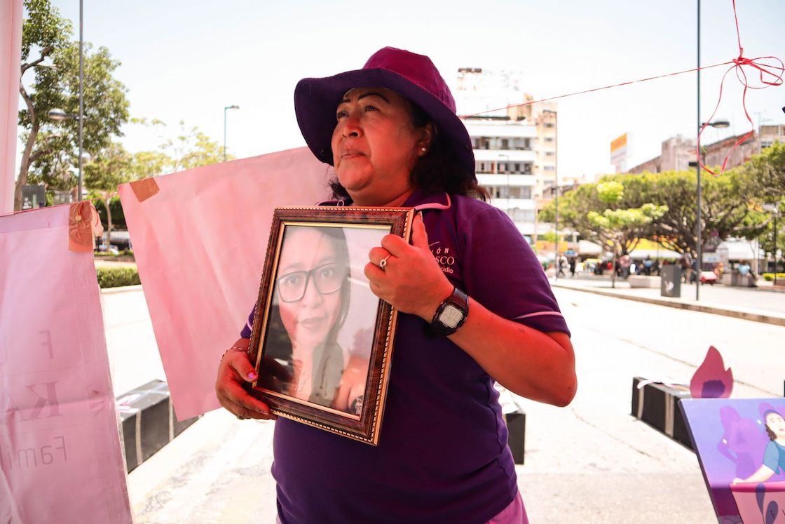 La madre de Karla Velasco sostiene su foto mientras pide justicia para su hija.