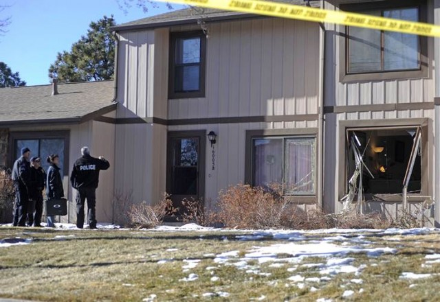 Police survey the outside of a townhouse complex following an overnight hostage-taking incident in Aurora