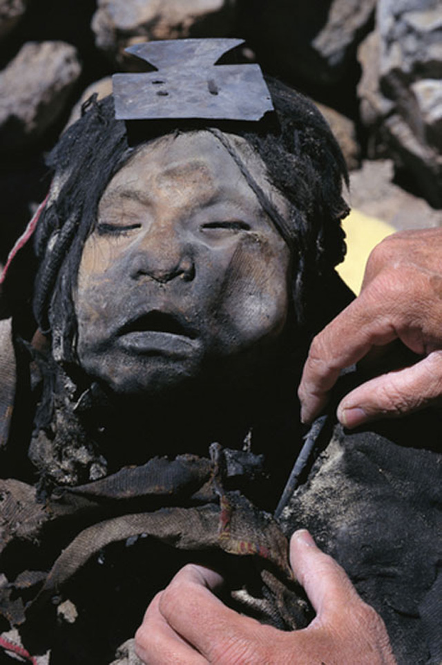 An archaeologist unwraps the mummy of a sacrificed Incan child.