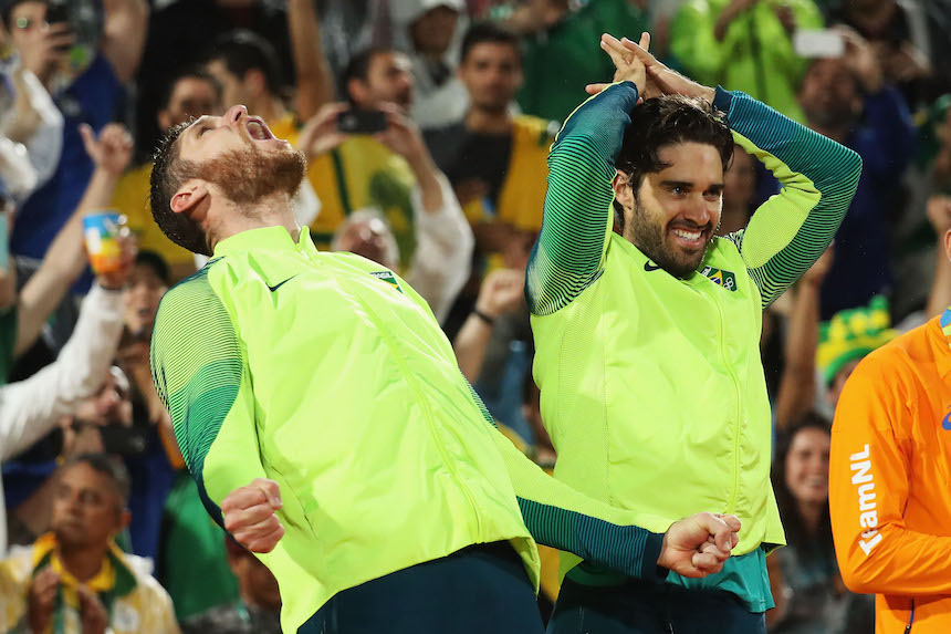 Alison Cerutti y Bruno Schmidt al momento de recibir su medalla de oro por la prueba de voleibol