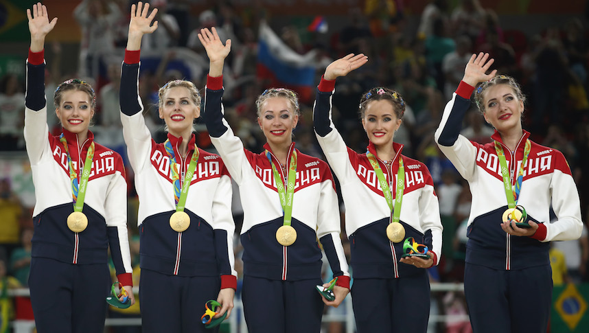 El equipo de gimnasia ritmica al momento de recibir la medalla de oro