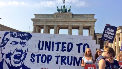 Activistas derriban un muro de cartón en Alemania e invitan a los estadounidenses que viven en ese país a votar en contra de Trump