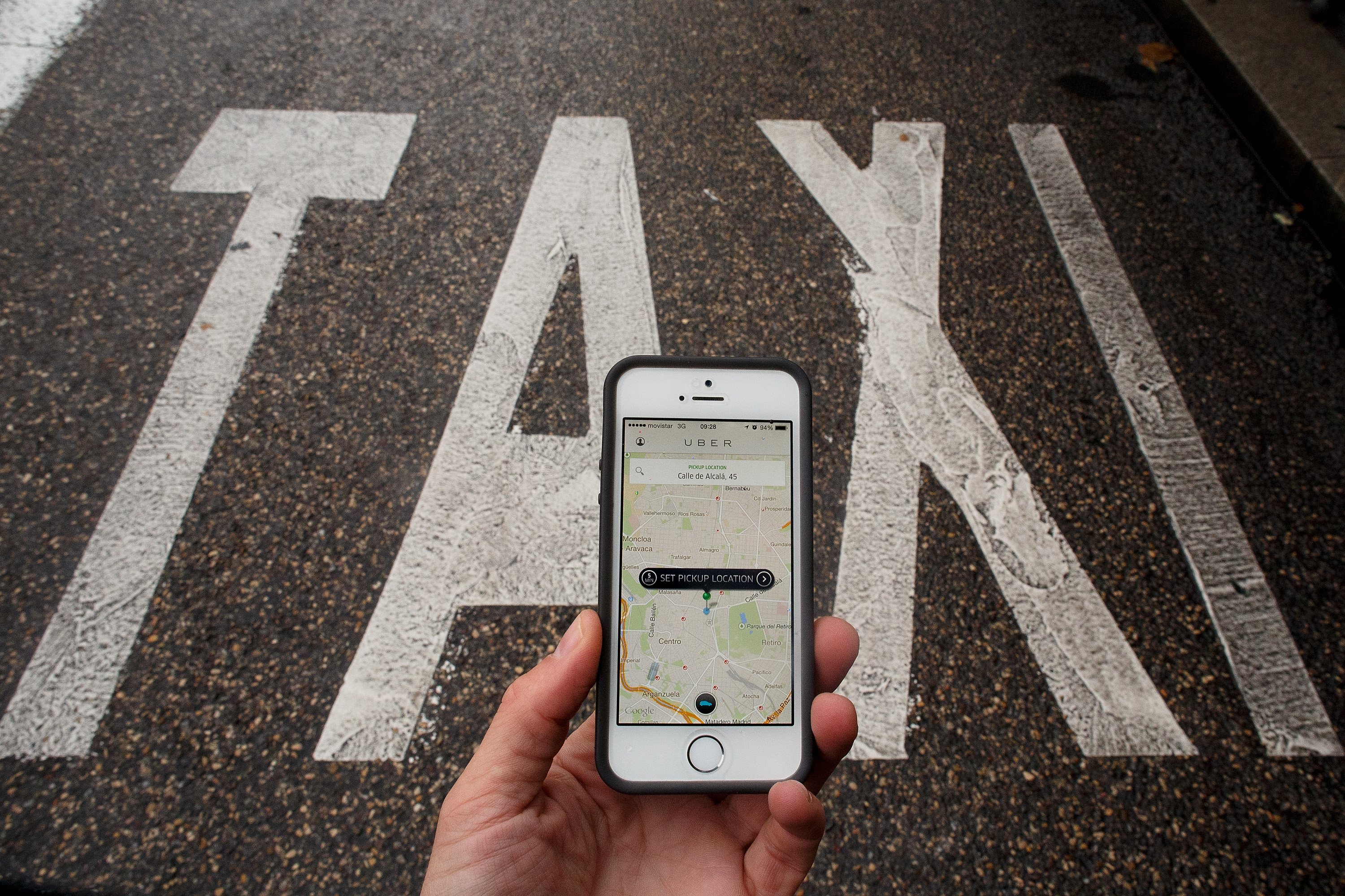 MADRID, SPAIN - OCTOBER 14: In this photo illustration the new smart phone taxi app 'Uber' shows how to select a pick up location next to a taxi lane on October 14, 2014 in Madrid, Spain. 'Uber' application started to operate in Madrid last September despite Taxi drivers claim it is an illegal activity and its drivers currently operate without a license. 'Uber' is an American based company which is quickly expanding to some of the main cities from around the world. (Photo by Pablo Blazquez Dominguez/Getty Images)