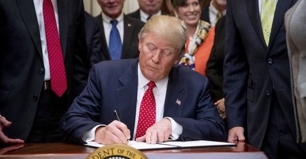 Trump firmando ley armas