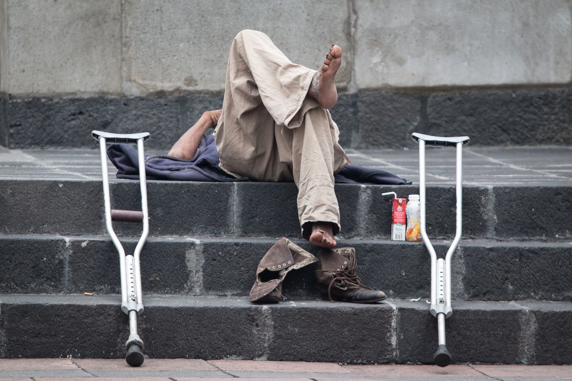 CIUDAD DE MÉXICO, 06JULIO2019.- Un hombre de la tercera edad en situacion de calle toma un descanso frente al Palacio de Minería.