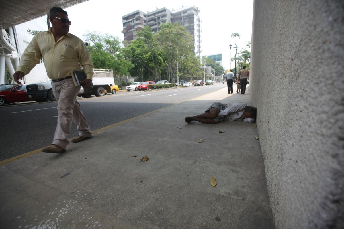 VILLAHERMOSA, TABASCO, 29MARZO2016.- Un adulto mayor en situacion de calle encuentra refugio sobre el muro del edificio conocido como MUSEVI, ubicado sobre el transitado Paseo Tabasco, a la altura del parque Tomas Garrido.