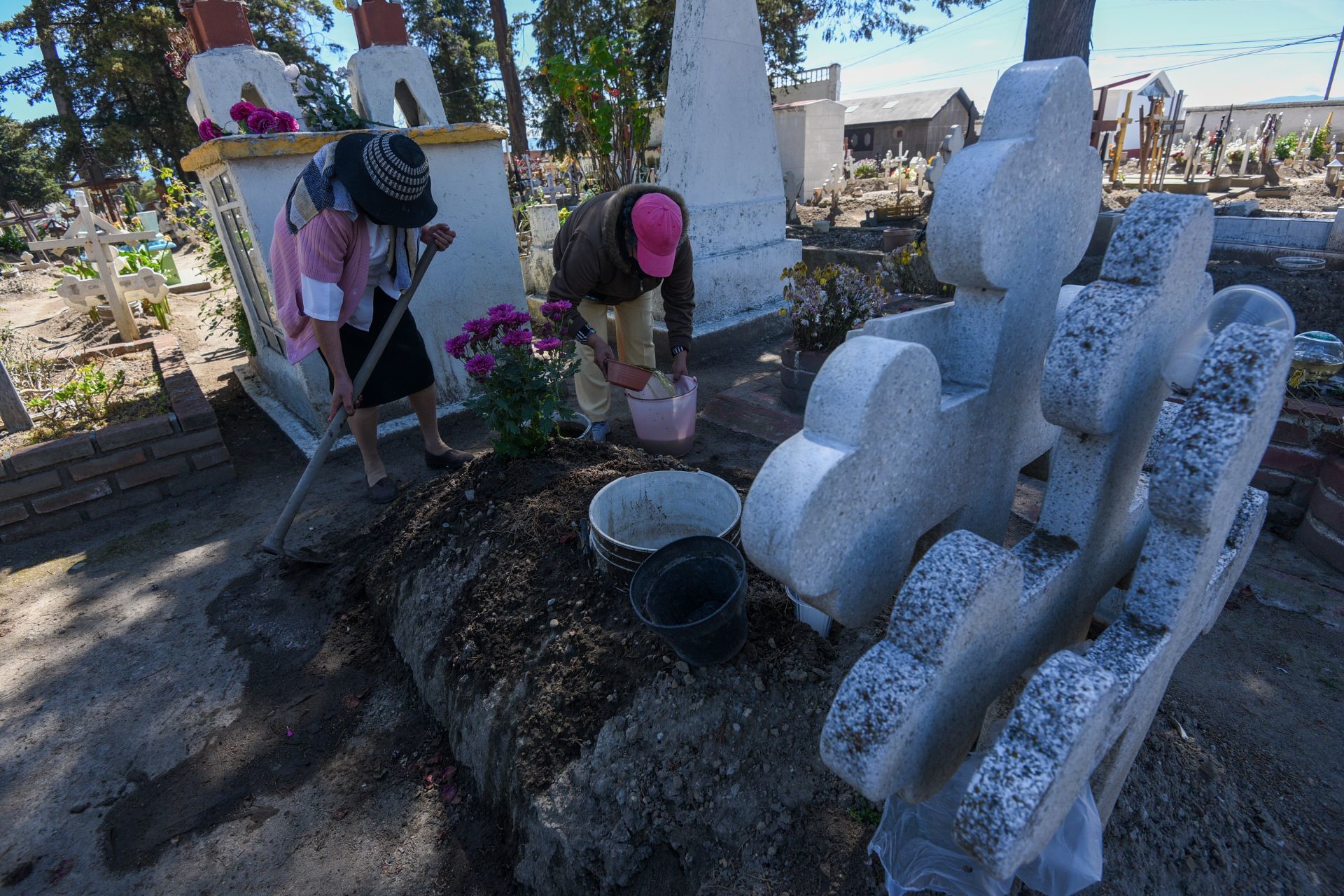 Previo a la celebración del Día de Muertos vecinos de Metepec acuden a los panteones a realizar limpieza general de las tumbas de sus familiares.