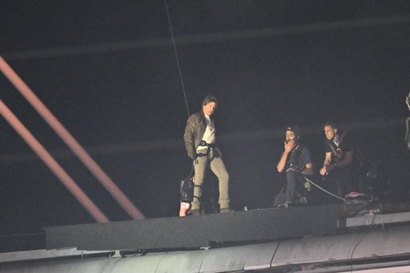 Tom Cruise asistido por dos personas en el Stade de France